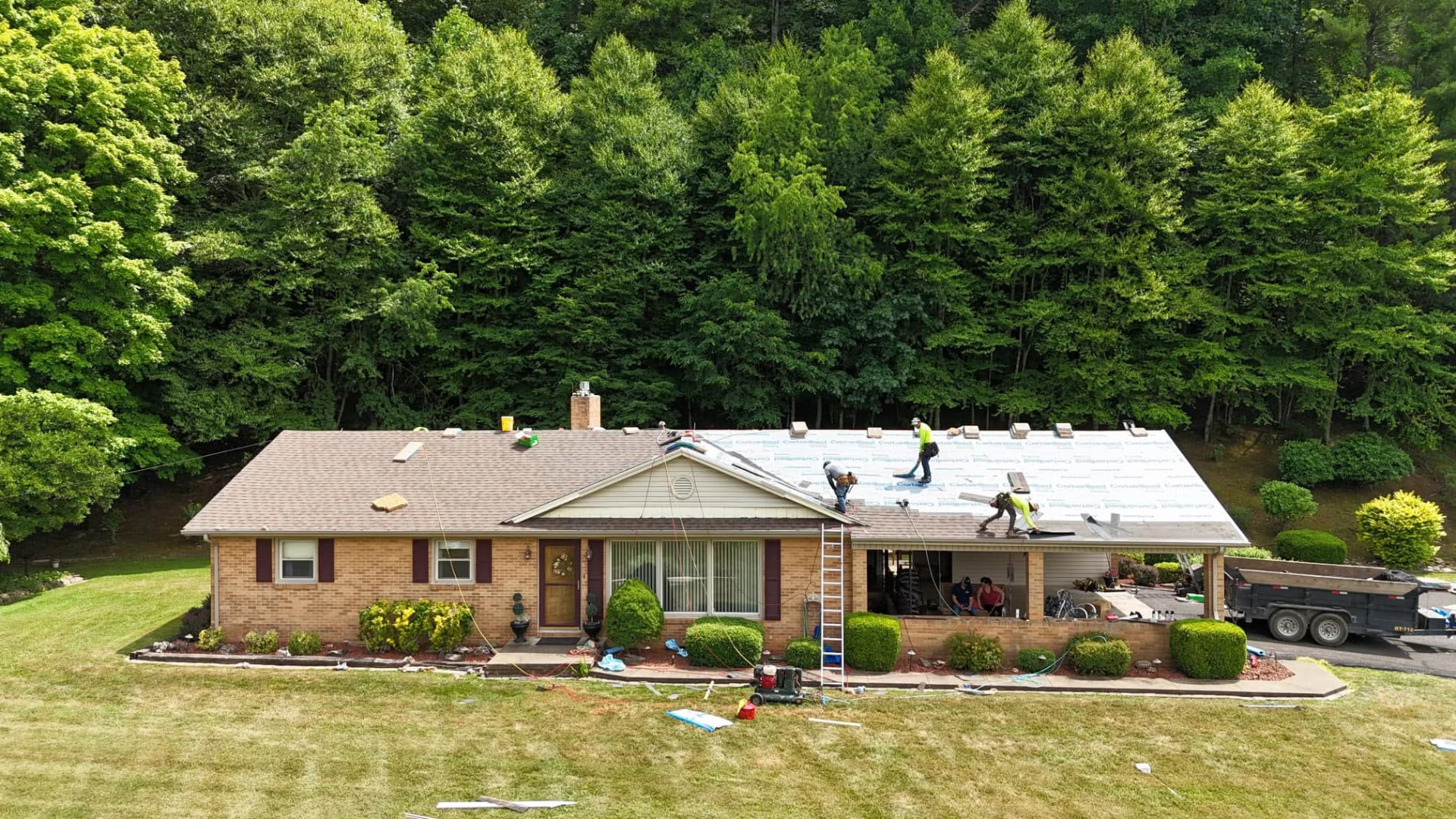 The Roof Authority crew replacing a roof on a brick ranch home